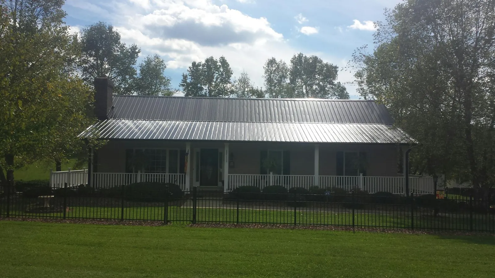 Gray metal roof on a brick ranch with a full width front porch — Gutter Guard Installation work by our crew in Wadsworth