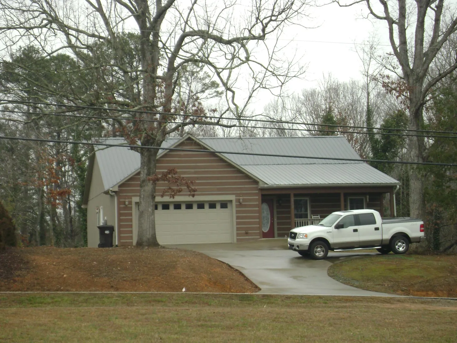 Gray metal roof on a log sided house with an attached two car garage in Wadsworth